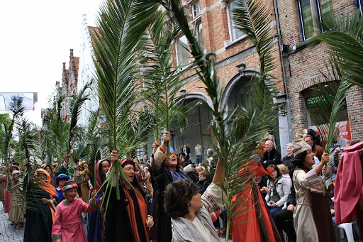 Люди несут пальмовые ветви.