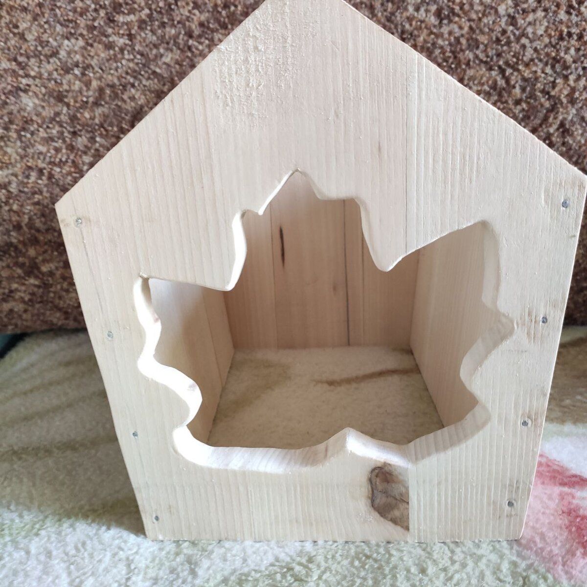 Отверстие в кормушке в форме кленового листа