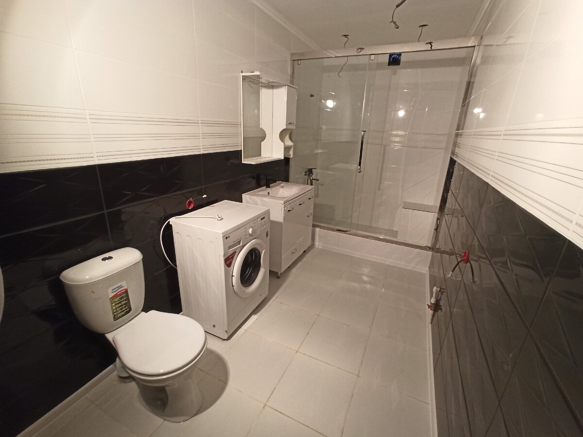 Установили унитаз, стиральную машинку, раковину с полкой и душевую стенку.