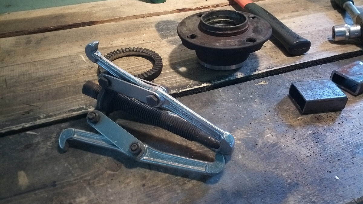 Трёхлапый съёмник подшипников на фоне задней ступицы.