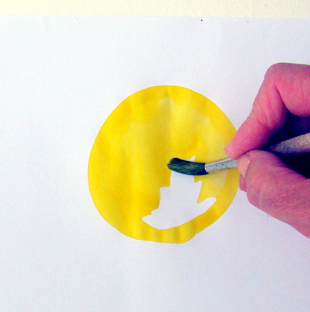 Наберите на широкую кисть жёлтой акварельной краски,  нарисуйте и закрасьте круг.