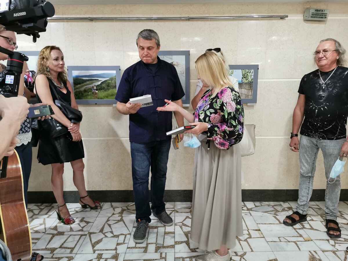 Писатель Жанна Швыдкая вручает свои книги "Огранка" и "Метаморфоза"  фотографу Александру Кадникову. Крым. 