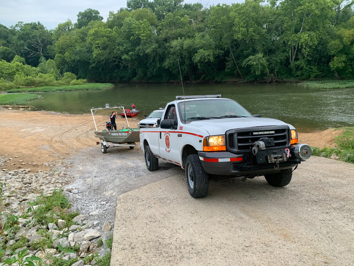 Браш трак с лодкой из пожарного депо Фармингтон задом сдает к реке для спуска лодки.