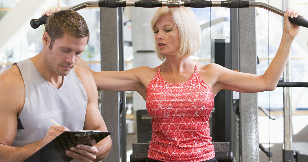 Занятие с тренером в тренажерном зале 