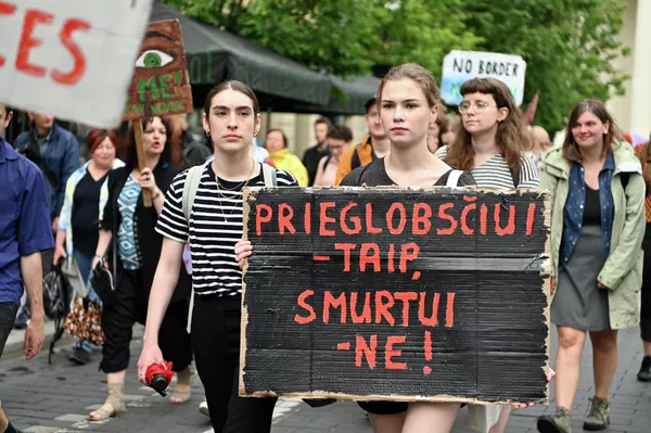 Активисты прошли по улицам столицы от здания Министерства внутренних дел до здания Правительства, где на площади им. Винцаса Кудирки провели небольшой митинг. Участница митинга с плакатом "Убежищу - да. Насилию - нет!"