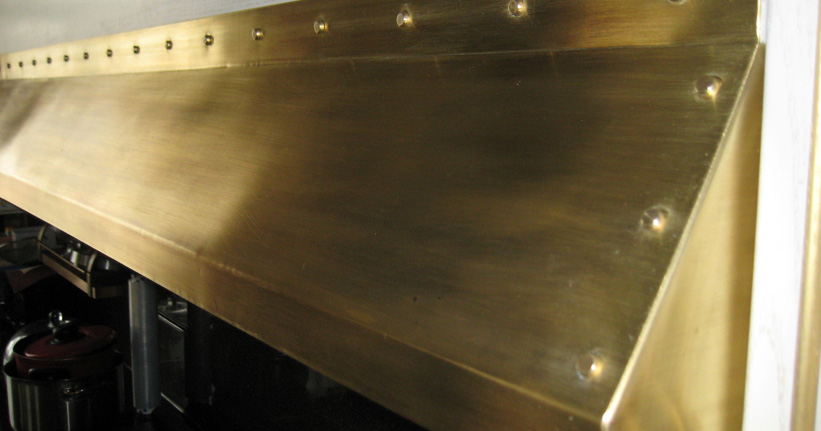Часто на кухне из латуни делают вытяжку и детали на духовке