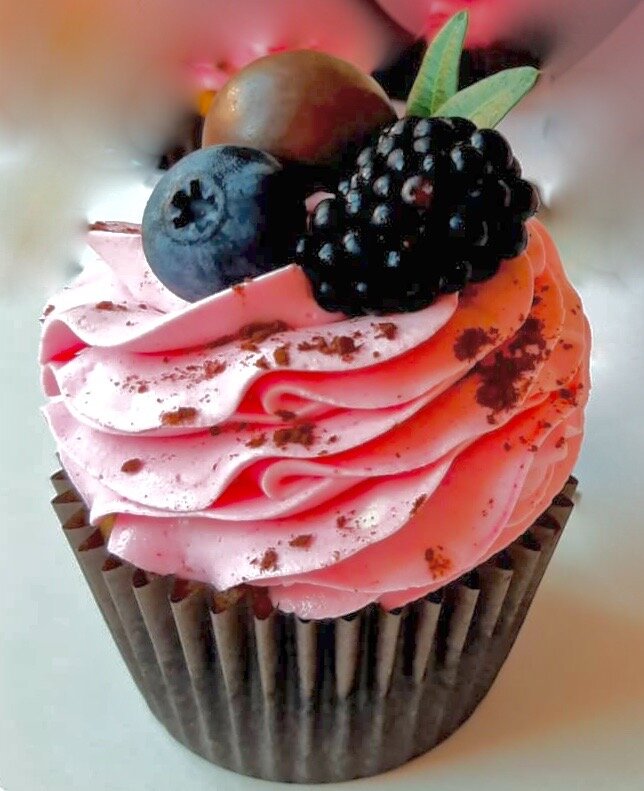 Капкейк с ягодным кремом, украшенный черникой и ежевикой.