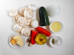 Как запечь шампиньоны с сыром в духовке? Подготовьте все необходимые ингредиенты. Выбирайте шампиньоны одинакового размера, не слишком мелкие. Я брала с диаметром шляпки около 4 см. Они должны быть снежно-белого цвета без пятен и повреждений, запаха гнили. На ощупь они не должны быть скользкими. Сыр берите нескольких видов. Я взяла 2 половины перцев разного цвета, чтобы начинка выглядела ярче. Помидор берите более мясистый.