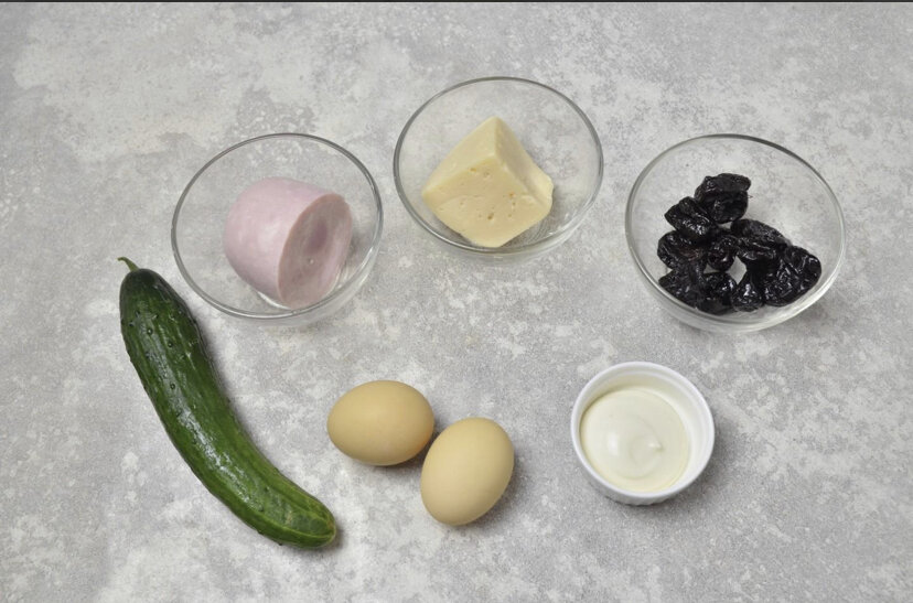 Как сделать салат Кролик с ветчиной и черносливом? Подготовьте продукты. Ветчину возьмите нежирную, натуральную, вкусную. Огурец — свежий, чернослив без косточек, сладкий. Яйца предварительно отварите и остудите. Морковь для украшения салата также отварите.