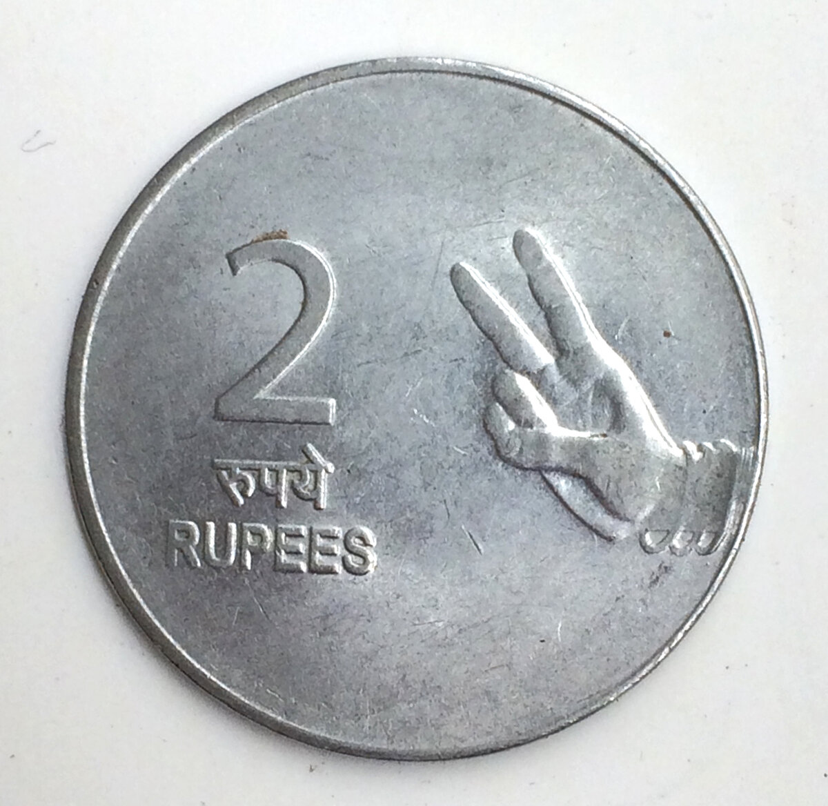    Монета в 2 рупии показывает два пальца.Alphabettes