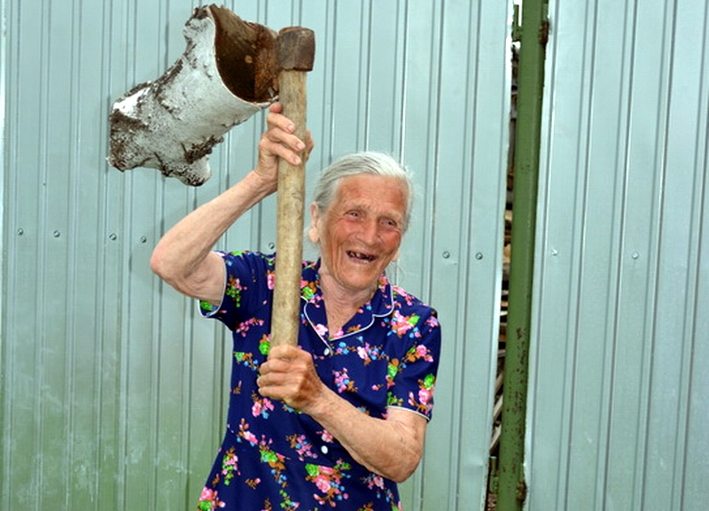 Пелагея Егоровна колет дрова в 90 лет