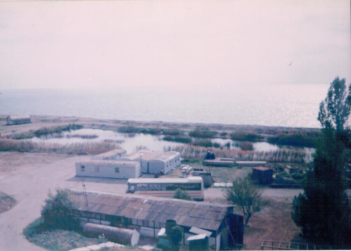 Самый правый вагончик – кухня и столовая. За вагончиками виднеется озерцо, а ещё дальше море. 