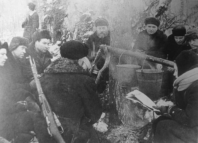Бойцы партизанского отряда Уваровского района на привале в зимнем лесу.                 Место съёмки: Уваровский район, Московская область.
Время съемки: февраль 1942.Автор: В.Зунин.
http://waralbum.ru. Военный альбом.
