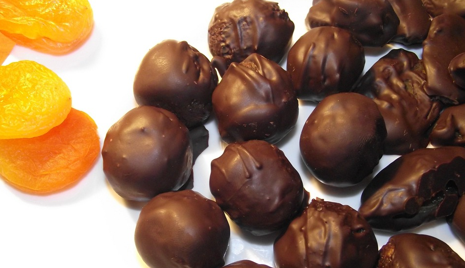 Изюм орехи конфеты и мармелад лежат. Чернослив и курага в шоколаде. Сухофрукты в шоколадной глазури. Конфеты сухофрукты в шоколаде. Конфеты с сухофруктами.