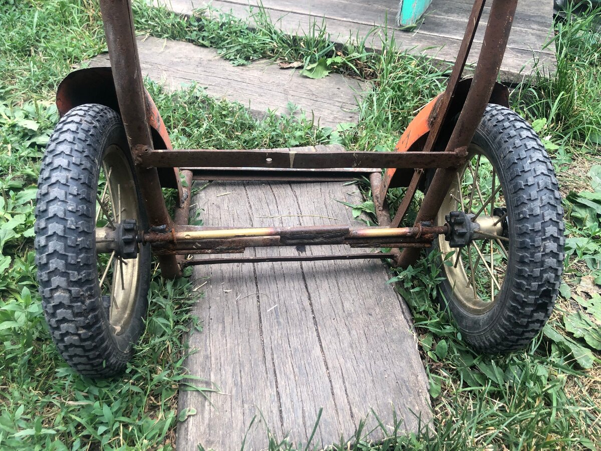 Колеса тачки держатся на оси, которая приварена к раме