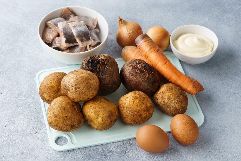 Подготовить все ингредиенты. Слабосоленую сельдь удобнее взять готовую и очищенную от костей, так приготовление салата займет меньше времени.Майонеза можно взять меньше, но важно пропитать все слои, особенно такие сухие, как картофельный. Если майонез на вкус достаточно соленый, можно практически не использовать соль.Для выкладывания селедки под шубой в виде рулета удобно использовать форму для выпечки или небольшой противень примерно 25 на 35 см