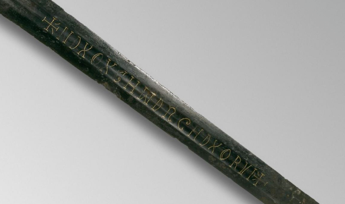 Надпись золотой проволокой на доле меча