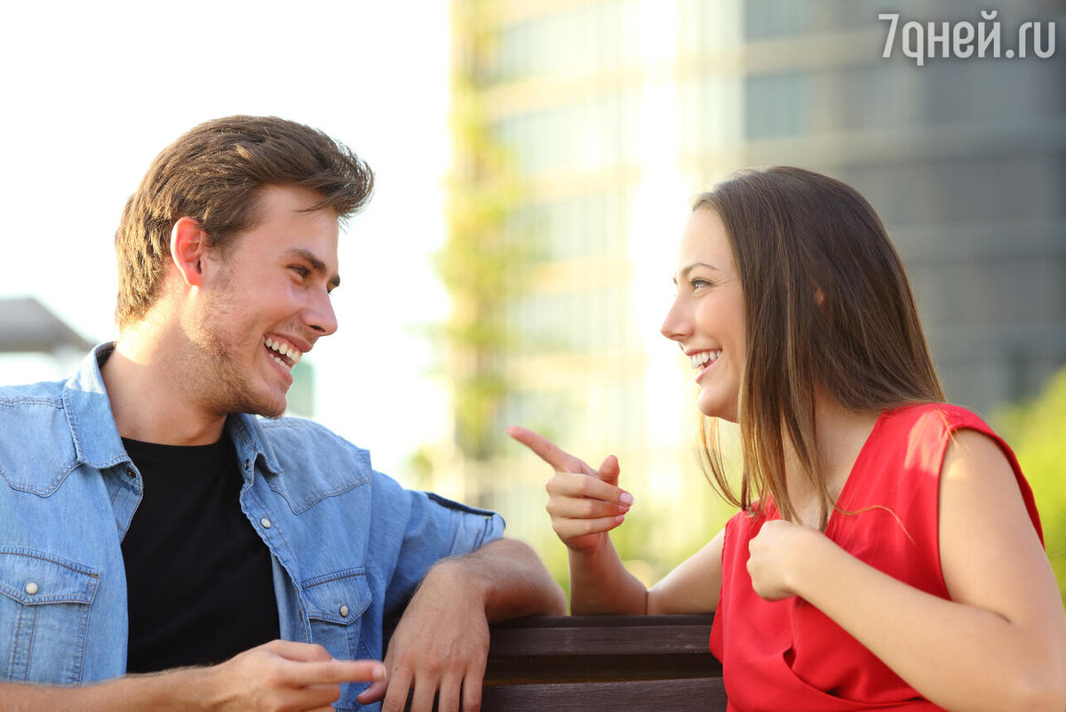 Женщина задает вопросы мужчине. Pleased couple sitting and talking.