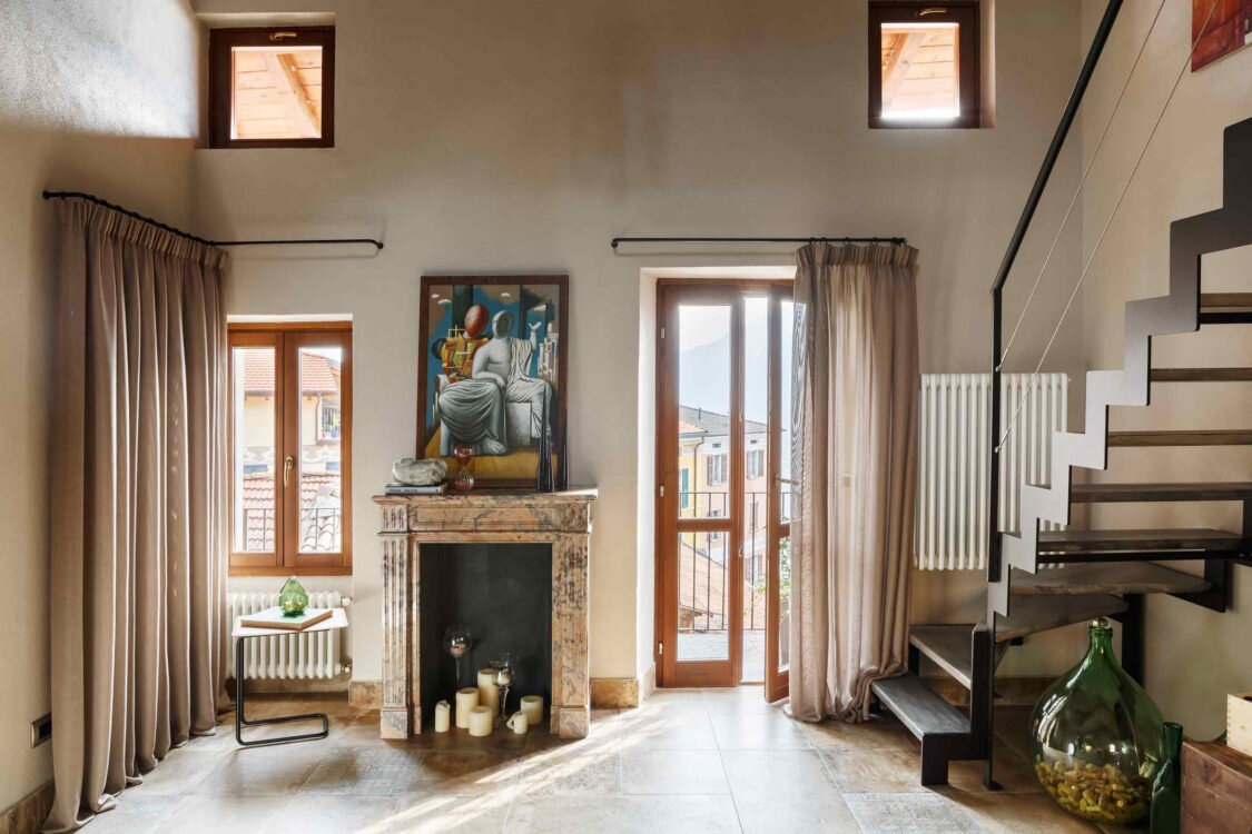 Зона гостиной. На полу керамогранит Terre d’Orcia, Unica; мраморный каминный портал антикварный; над ним работа неизвестного автора; стены покрыты краской, Farrow & Ball; слева от камина, за шторой, скрывается кладовка.