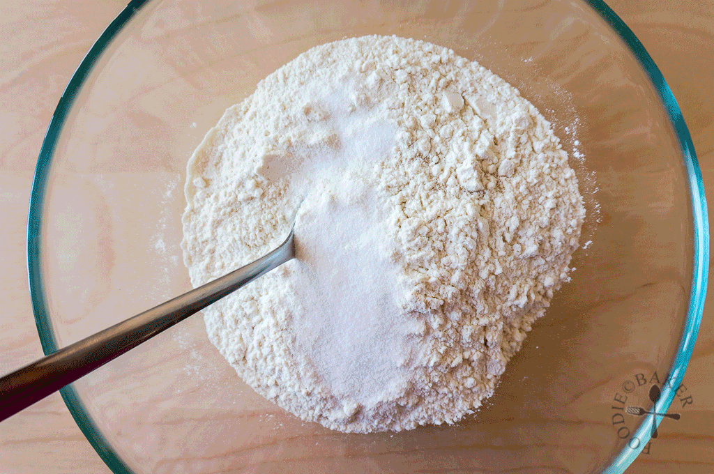 Приготовьте тесто для тонкой пиццы. Сухие дрожжи насыпьте в маленькую мисочку и залейте 3 ст. л. теплой воды. Перемешайте ложкой и оставьте на 15 минут, чтобы дрожжи активировались.Муку с солью просейте через частое сито на рабочий стол в виде горки. Сверху сделайте небольшой «колодец». Влейте в него дрожжевую смесь, оставшуюся воду и начните вилкой или рукой замешивать тесто.Перемешивайте тесто для пиццы по кругу, все время в одном направлении, захватывая муку со стенок «колодца». Затем добавьте в тесто 1 ст. л. оливкового масла и вымешивайте до гладкости в течение 10 минут.