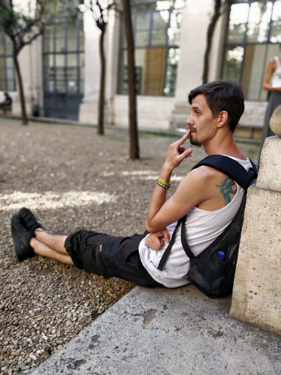 Саша наслаждается тёплым деньком в Италии во дворике библиотеки