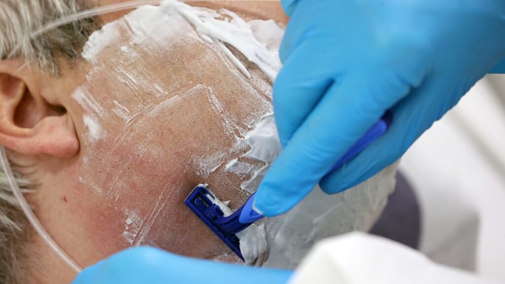 Волонтер бреет лежачего пациента отделения реанимации и интенсивной терапии (ОРИТ) городской клинической больницы №52. У большинства добровольцев есть постоянная работа, однако они находят время для волонтерской деятельности в больнице. Фото: Владимир Гердо/ТАСС