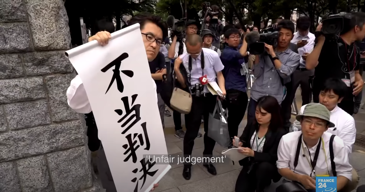 Надпись "Несправедливое решение". Судебный процесс о принудительной стерилизации. Япония, 2019 год. Картинка с видео France 24 на Ютубе.