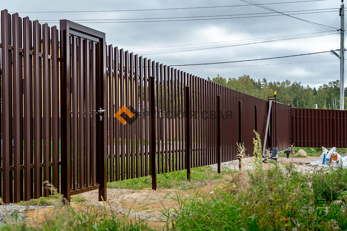 Забор и откатные ворота из металлического штакетника, установленные в Сосновских озерах компанией Русская Свая