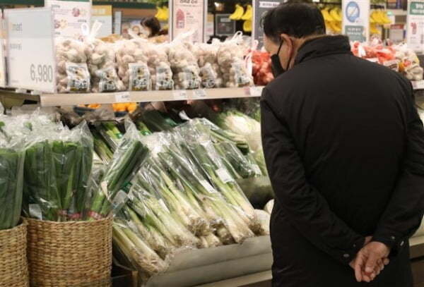 Мужчина делает покупки в отделе продуктов на местном рынке в Сеуле. (Ренхап)