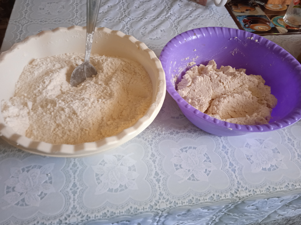 Смешать муку, сахар, соду. Добавить натëртую пачку маргарина. Получится крошка. В творог добавить яйца, ванилин, можно изюм или фрукты. 