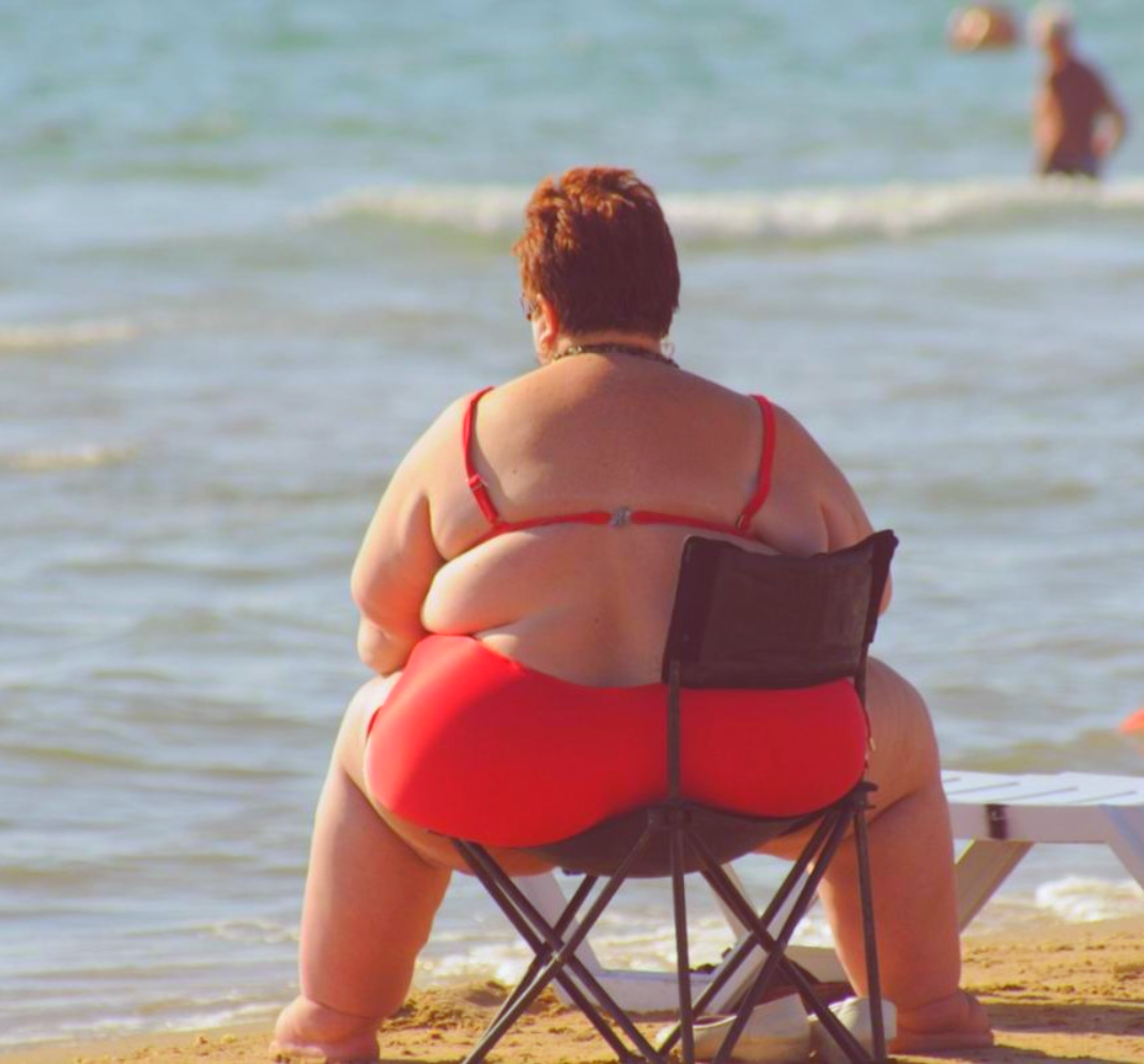 Толстухи сидят. Толстая женщина в купальнике. Толстие женшини на пляже. Жирные на пляже. Жирные женщины на пляже.