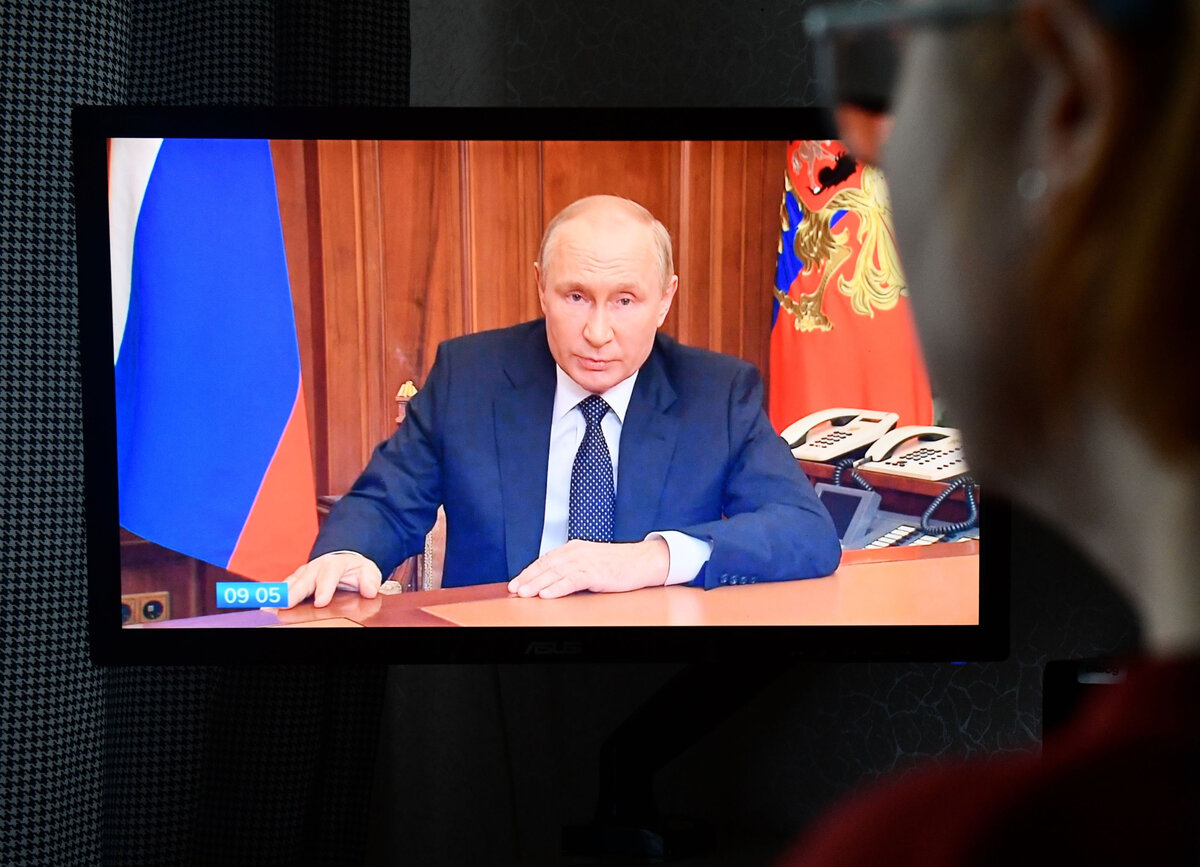Женщина смотрит трансляцию срочного телеобращения президента РФ Владимира Путина к гражданам России, 21 сентября 2022 // Sputnik / Павел Лисицын