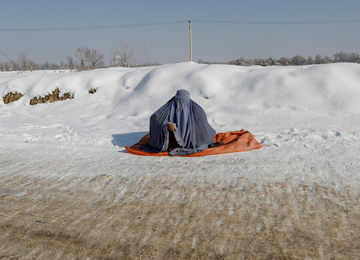 Афганская женщина в парандже на заснеженных улицах Кабула/Reuters