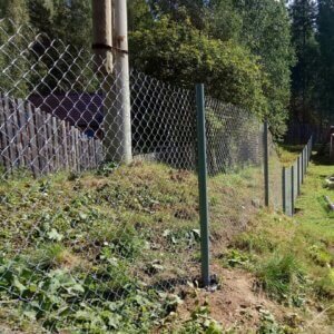 Бюджетный и надёжный вариант, имеет привлекательный внешний вид. К тому же вы можете выбрать сетку из различных материалов. Например, забор из сетки-рабицы состоит из спиралей, покрытых полимерным составом, который делает сетку прочнее и устойчивее к погодным условиям. Если на участке имеются посадки овощей, фруктов и цветов, то можете не беспокоиться насчёт проходимости солнца и ветра, забор хорошо пропускает и то, и другое.