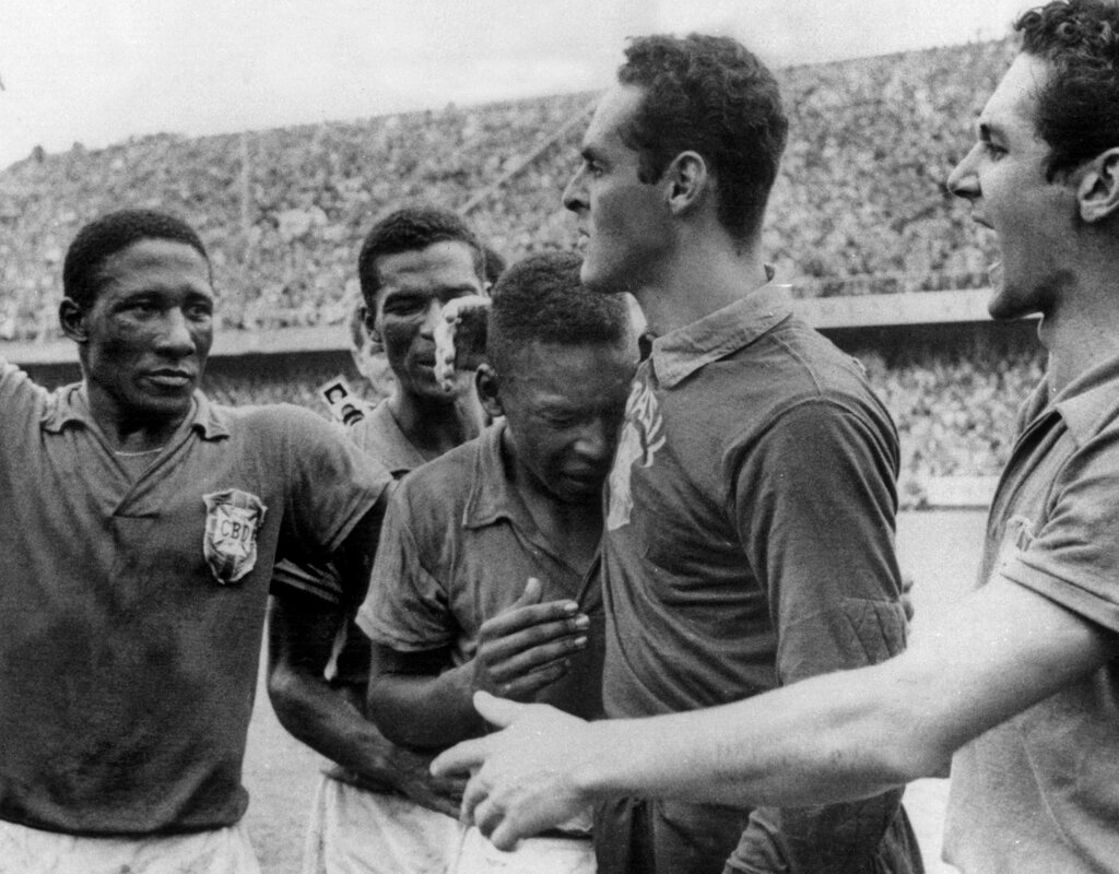 Жильмар после финального матча обнимает растроганного Пеле. Рядом с ними - Джалма Сантос, Диди и Орландо.