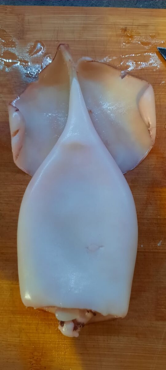 Кальмар замочить в кипяток на 20-30 секунд, затем очистить его от плёнки.