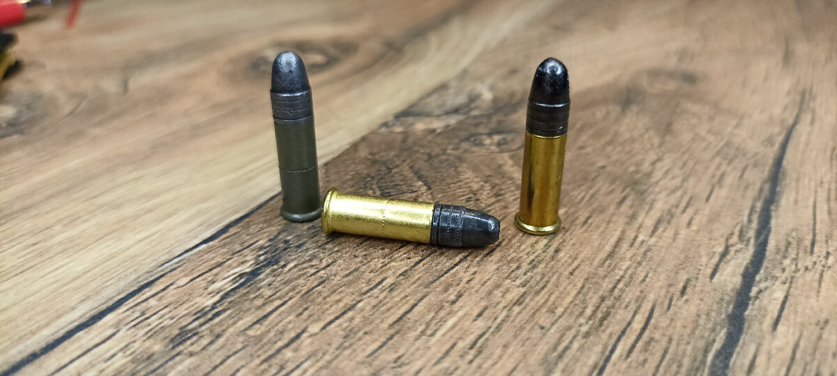 Патроны 22lr. Слева направо : охотник 370 с ( сплошная пуля) охотник 410 в латунной гильзе  с экспансивной пулей, sk biathlon