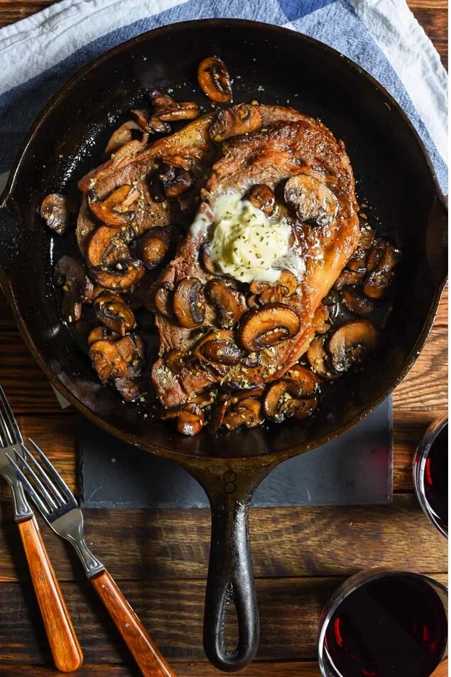 Ингредиенты:
стейк говяжий толщиной 2,5 см — 4 шт. (по 120 г)
грибы шампиньоны  — 4 стакана (примерно 240 г)
тимьян свежий (рубленый) — 0,5 ч. л.
соль — 0,5 ч. л.
перец черный молотый — 0,25 ч. л.
масло растительное
масло сливочное — 2 ч. л.
чеснок (измельченный) — 2 зубка
уксус бальзамический — 2 ст. л.
вода — 1 ст. л.
соус соевый — 1 ч. л.
тимьян свежий — 1 ст. л..Приготовление:
1. Стейки посыпать со всех сторон 1/4 ч. ложкой соли и 1/8 ч. ложкой перца. Большую сковороду разогреть на средне-сильном огне, смазать маслом. На разогретую сковороду выложить стейки, жарить около 3 минут с каждой стороны. Переложить мясо на тарелку.
2. Ту же сковороду разогреть на средне-сильном огне, добавить сливочное масло, растопить его в течение примерно 15 секунд. Выложить в сковороду чеснок, готовить, помешивая, около 30 секунд.
3. Добавить в сковороду грибы, 1/2 ч. ложки тимьяна, 1/4 ч. ложки соли и 1/8 ч. ложки черного молотого перца. Готовить, помешивая, около 3 минут, до мягкого состояния грибов.
4. Добавить в сковороду уксус, 1 ст. ложку воды и соевый соус, готовить около 1 минуты, почти до полного выпаривания жидкости.
5. Стейки подавать на порционных тарелках, а сверху выложить грибное соте. Посыпать блюдо тимьяном. На гарнир можно подать картофельное пюре и брокколи (по желанию).
Источник.