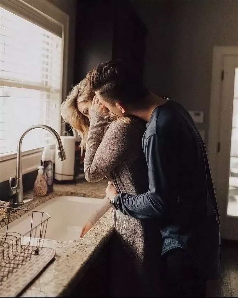 Пара обнимается на кухне