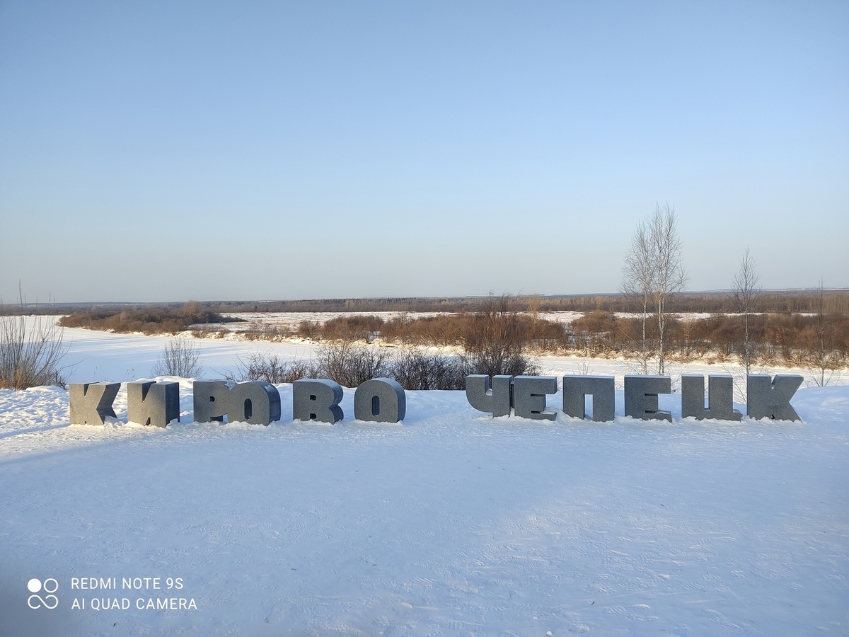 Сразу за буквами - высокий обрыв к реке. На другом берегу - заливные луга. Фото автора.