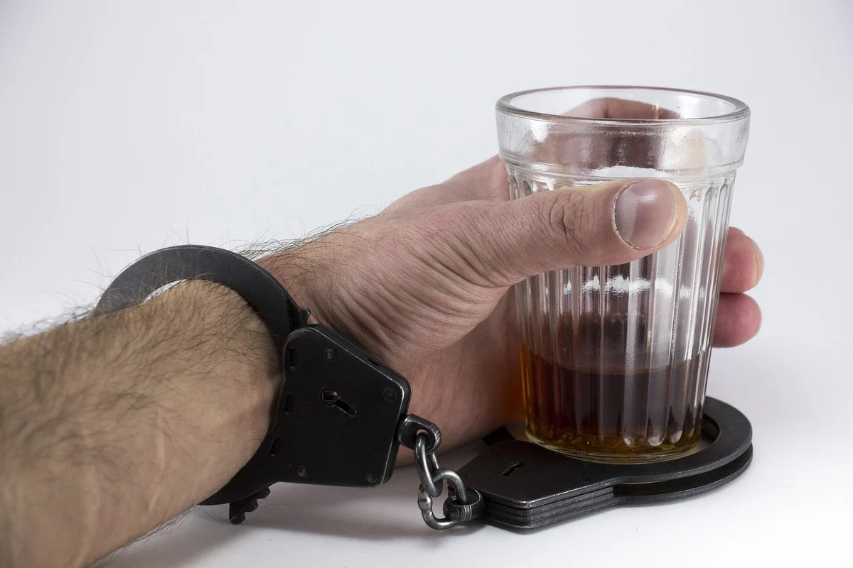 Фото https://pixabay.com/photos/alcohol-glass-hand-handcuffs-1901845/.