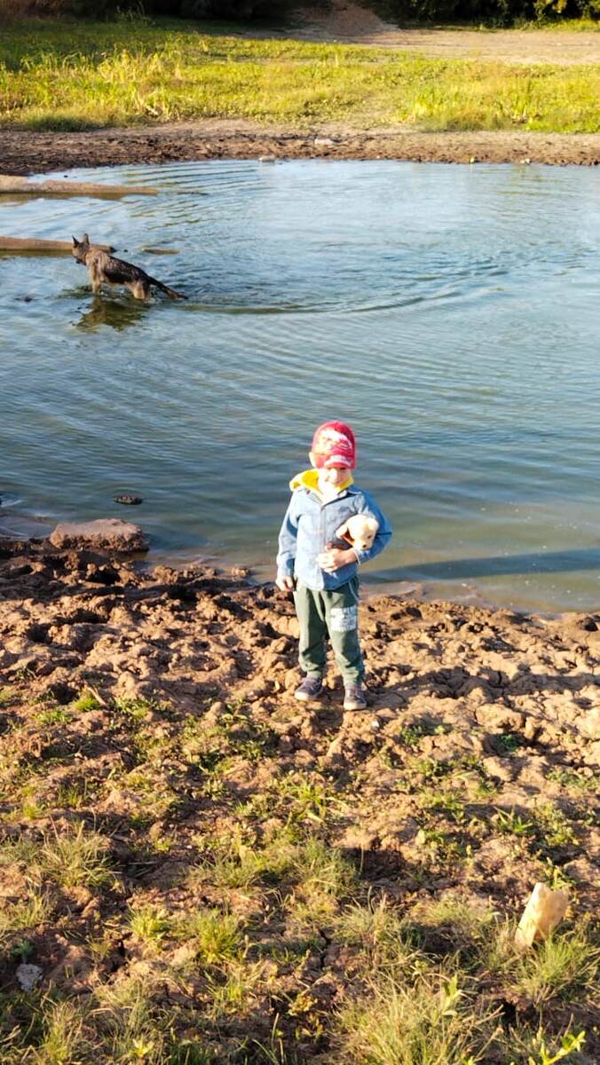 На заднем фоне Булик радуется воде. На переднем - Тимка обнимает своего пёсика.