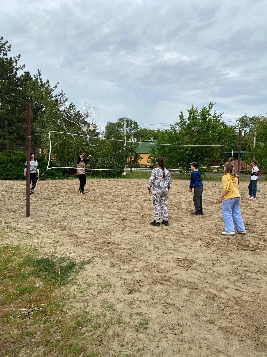 Дети с родителями играли в волейбол. 