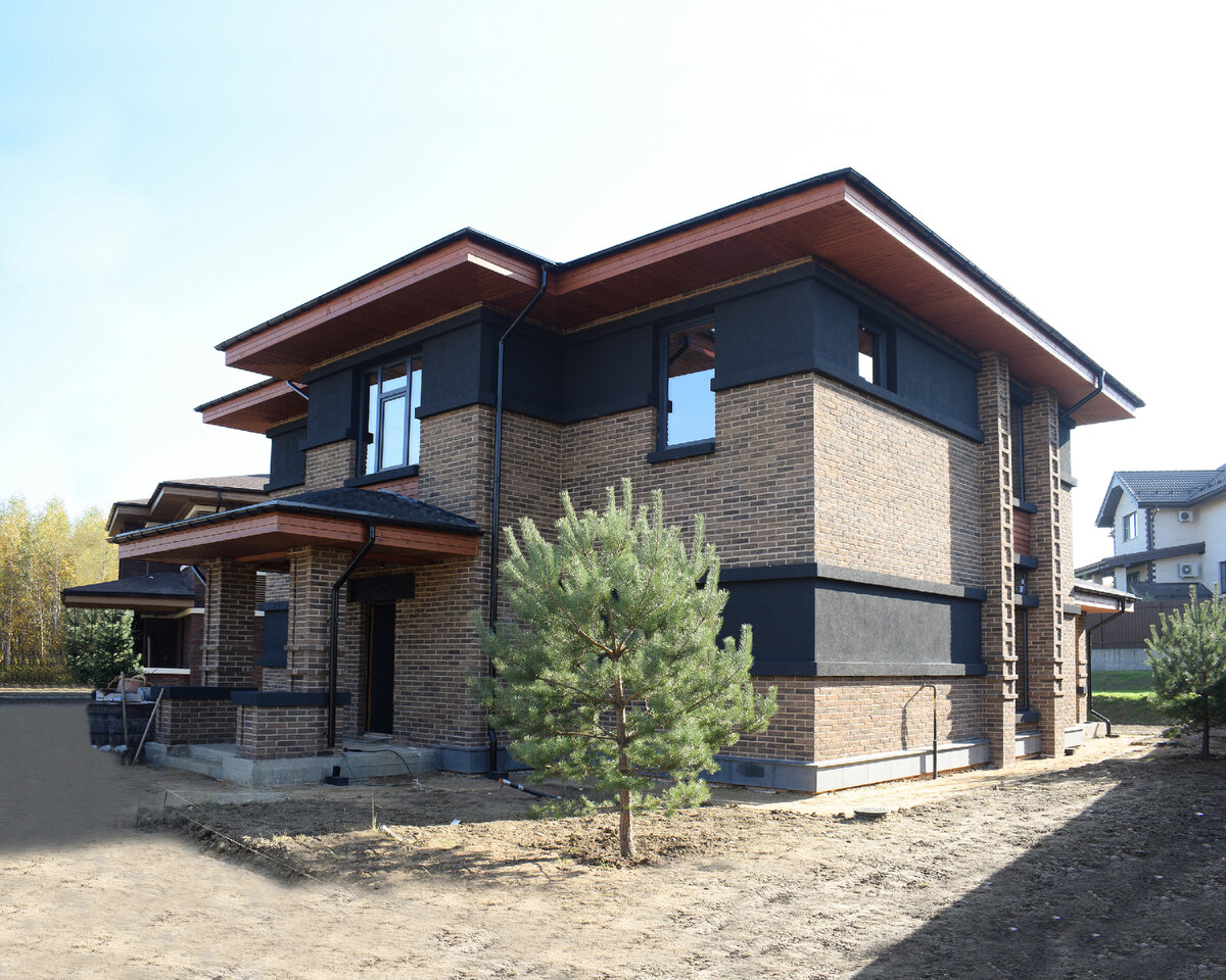 В отделке фасадов использованы кирпич ручной формовки, штукатурка глубокого серого цвета и декоративные элементы из натурального дерева.