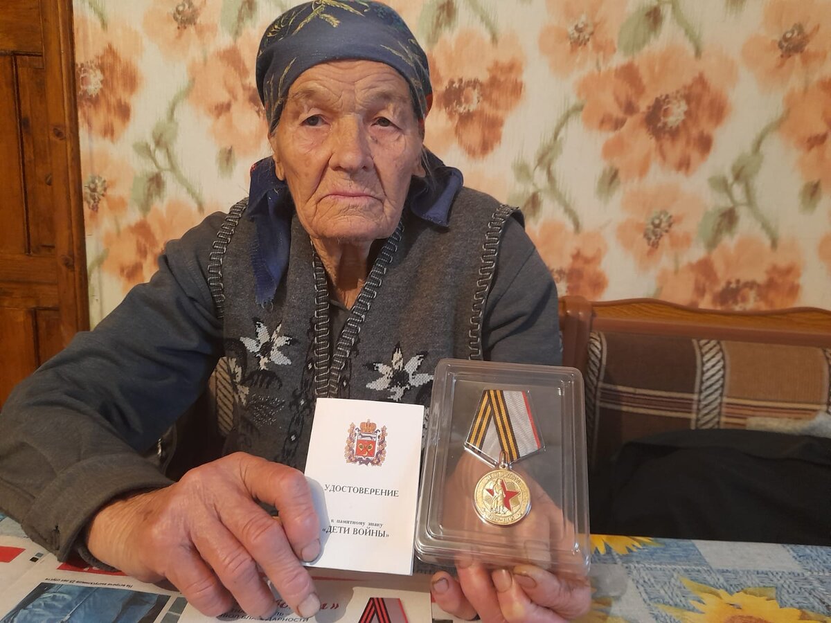 Мама позирует с медалью