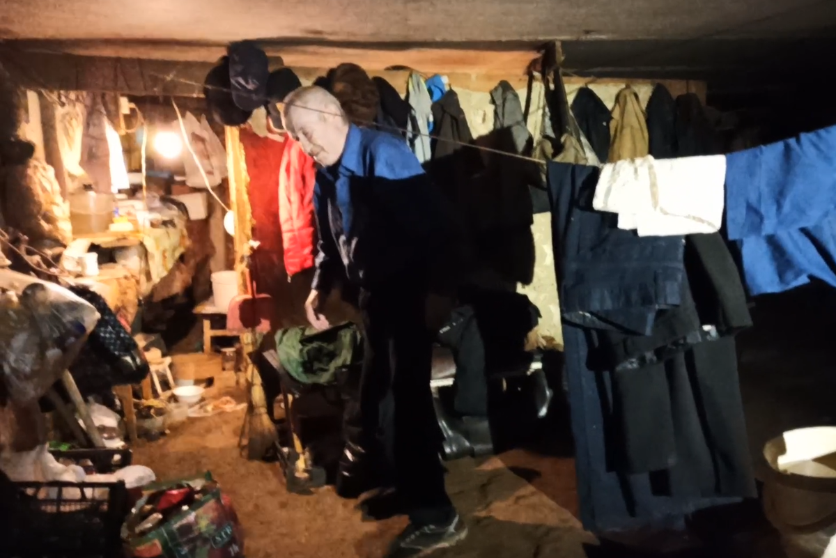 Часть подвала бездомный оградил фанерными щитами