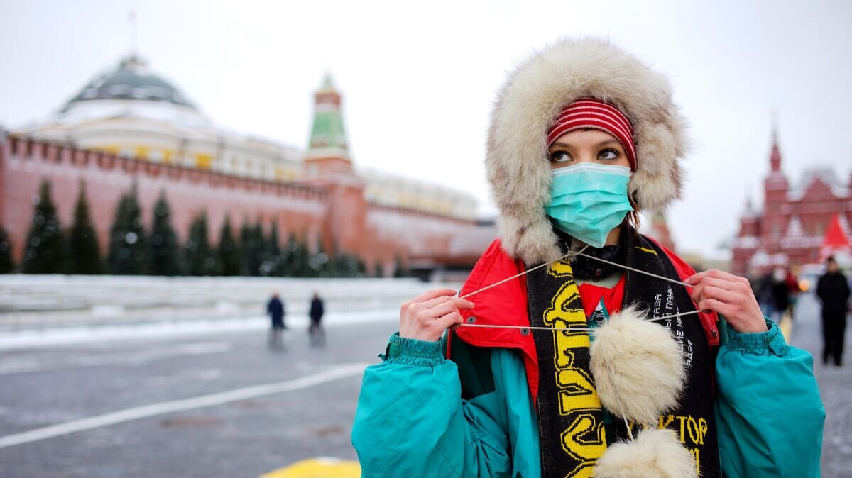    Девушка в защитной маске на Красной Площади в Москве© РИА Новости / Сергей Пятаков