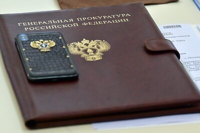    Папка для бумаг и телефон с логотипом Генеральной прокуратуры РФ. ©Алексей Куденко РИА Новости