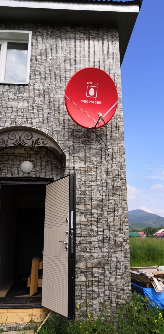 Установка спутниковой антенны на фасаде дома.