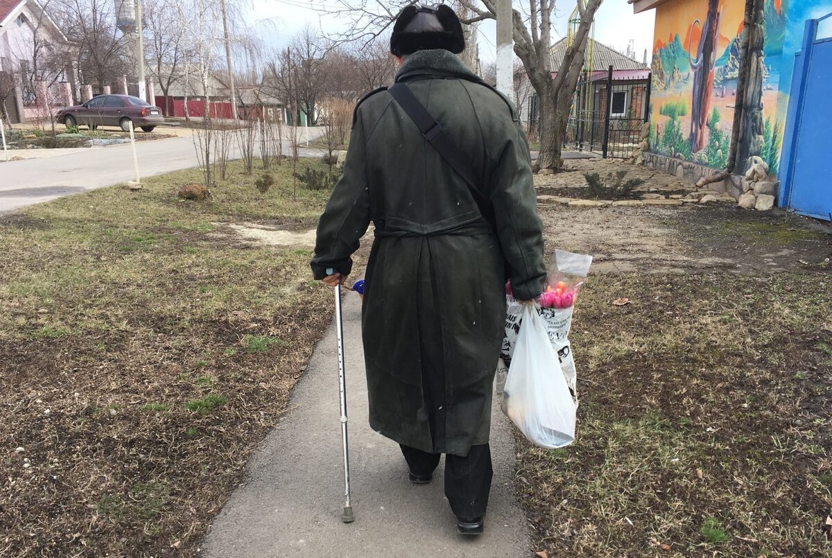 Трогательное фото, где дедушка несет тюльпаны для любимой женщины